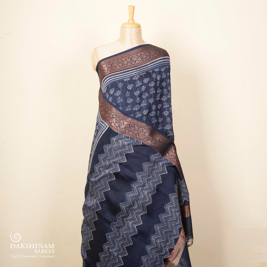 Dark blue Chanderi silk cotton saree with white lotus floral print, silver zari border and striped pallu