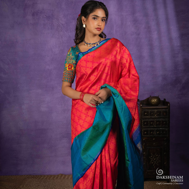 Orange no-zari Kanjivaram silk saree with light orange thread detailing, peacock green long border with silver zari lines, peacock blue pallu and matching blue blouse.