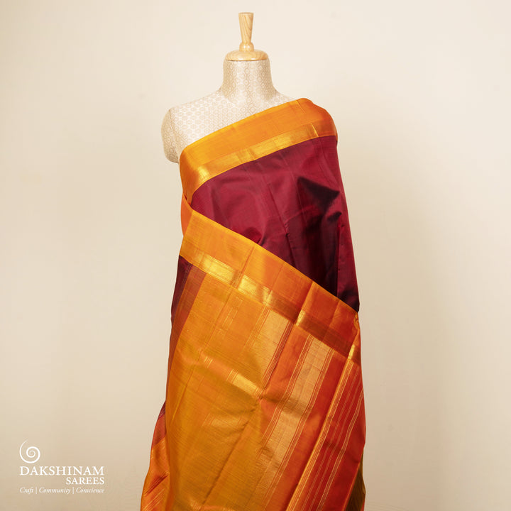 Maroon handwoven Kanjivaram silk saree with mango yellow border, gold zari and contrast pallu