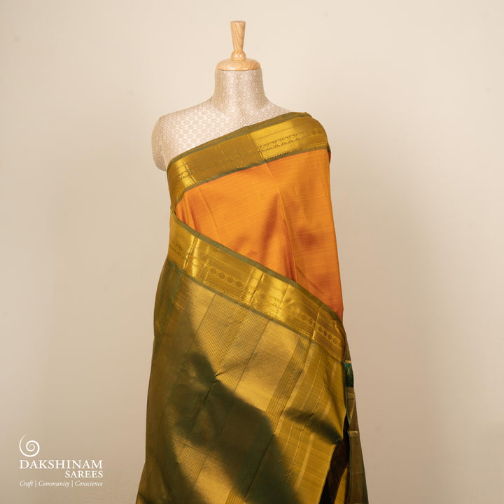 Mango yellow handwoven Kanjivaram silk saree with dark green border, gold zari and temple motifs