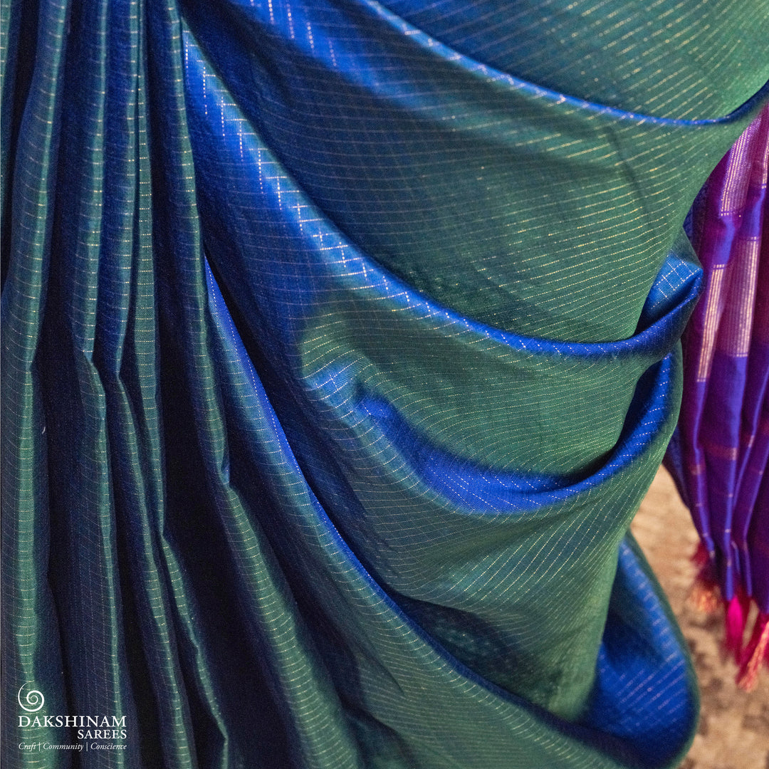 Peacock blue Korvai Kanjivaram silk saree with gold zari Vairaoosi checks, magenta contrast border, peacock motifs, diamond panel and striped pallu, paired with magenta blouse.